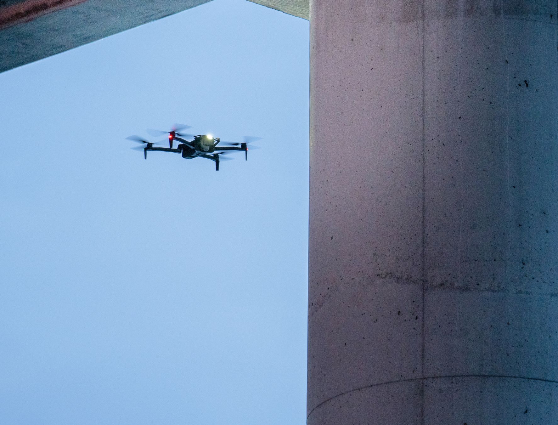 Skydio 2+ drone flying underneath a bridge