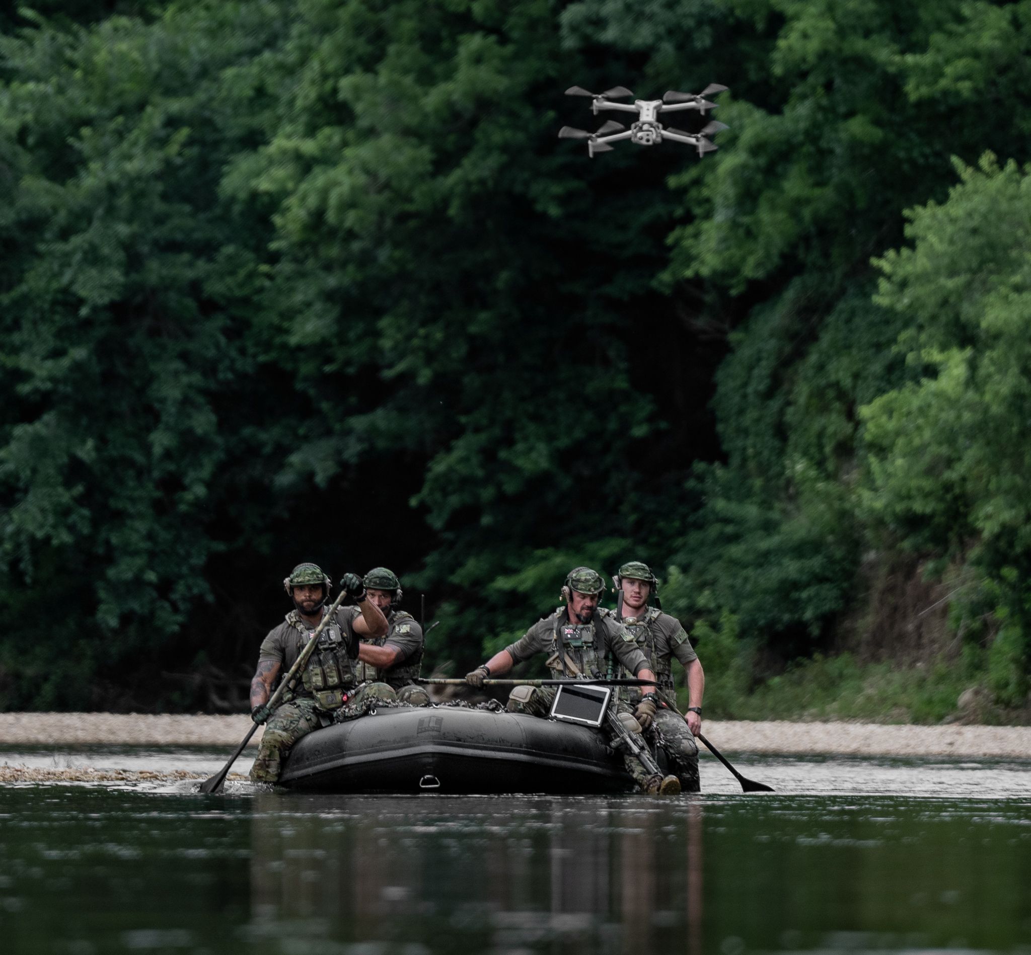 Special operations rowing on a river with X10D flying above