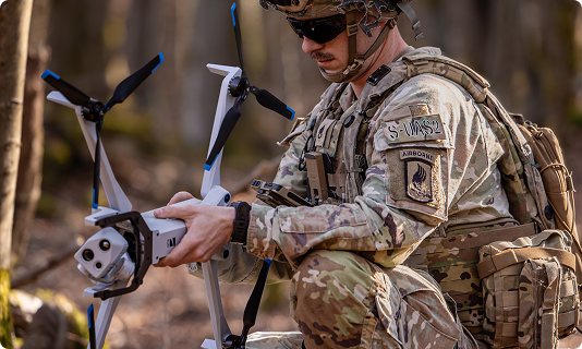 Airborne Troop getting Skydio X10 drone ready to launch in forested environment