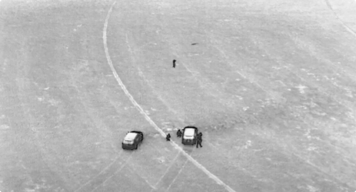 Skydio X10 drone thermal image of two police vehicles, officers and subject