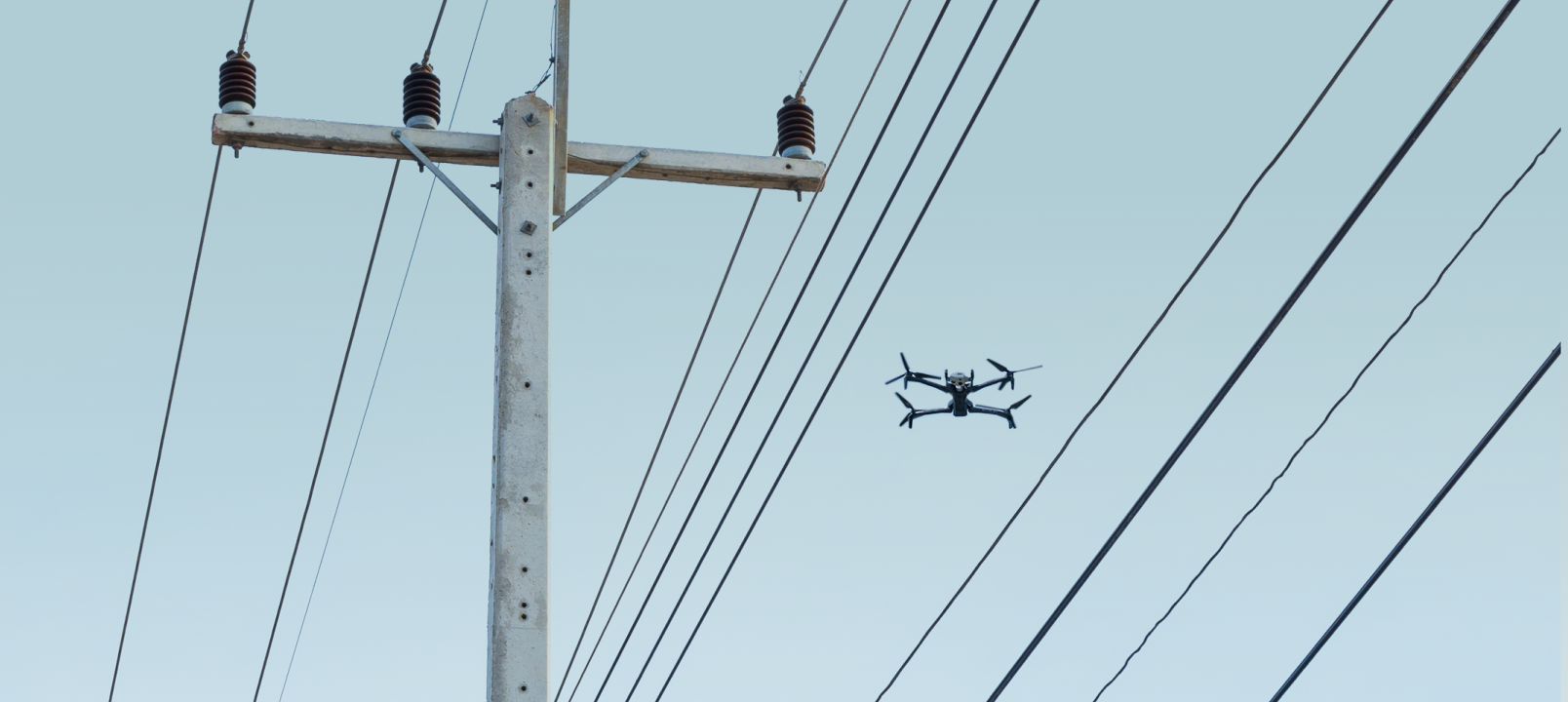 Skydio X10 inspection drone flying over electrical wires
