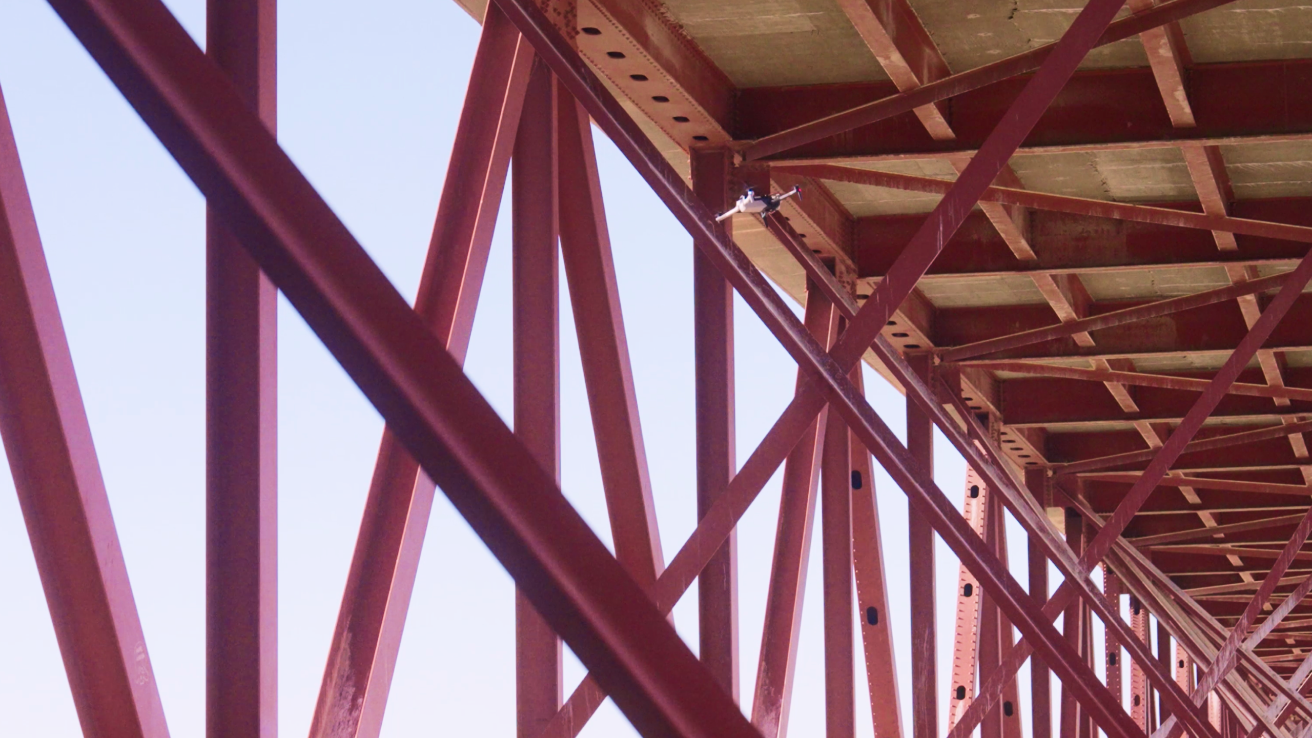 Skydio X10 inspection drone flying under steel bridge infrastructure